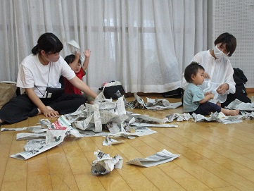 新聞紙遊びを楽しむ親子