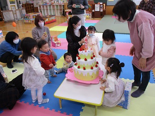 誕生会のケーキを囲む子どもたちのようす