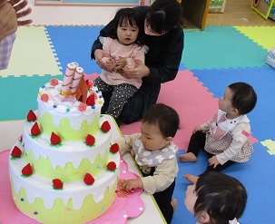 誕生日ケーキに集まる子どもたち